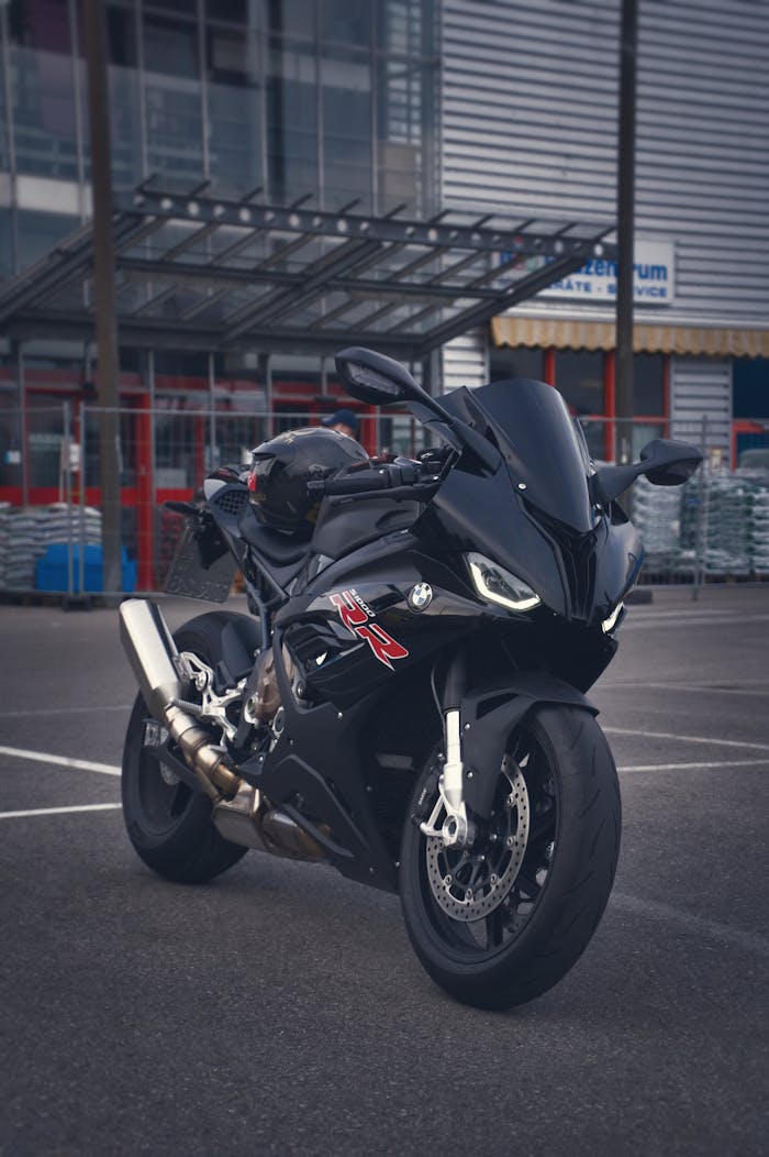 Dynamic shot of a black BMW S1000RR sports bike parked in a city environment.